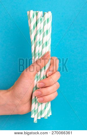 Woman Is Holding Green And White Paper Straws In Hand