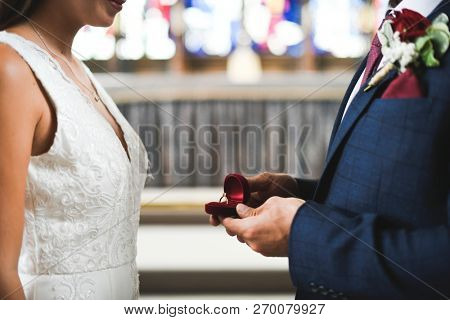 Groom taking out the wedding ring