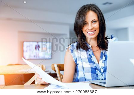 Woman with papers in their living room
