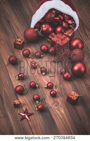 Beautiful Red Decorative Balls, Stars And Gift Boxes In Santahat, Lay On Wood Board With Copy Space.