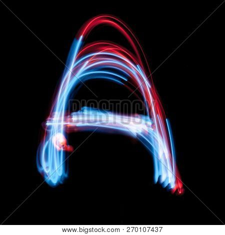 Letter A Of The Alphabet Made From Neon Sign. The Blue Light Image, Long Exposure With Colored Fairy