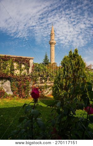 Cappadocia, Turkey: Mosque Minaret On The Background Of Red Rose Flowers