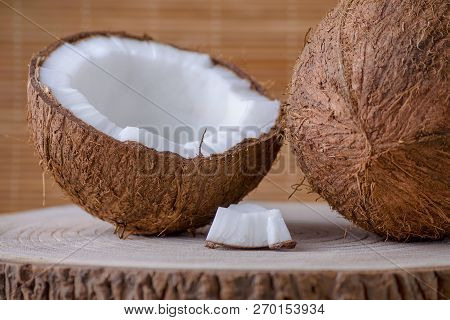 Coconut Whole, Half And Piece On Brown Natural Background