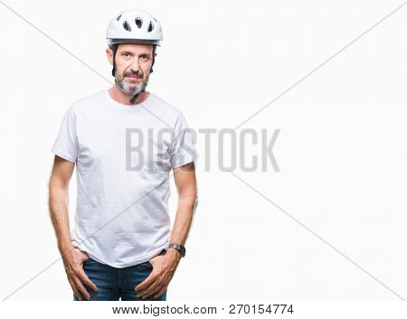 Middle age senior hoary cyclist man wearing bike safety helment isolated background with serious expression on face. Simple and natural looking at the camera.