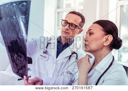 Serious International Woman Looking At Roentgen Picture