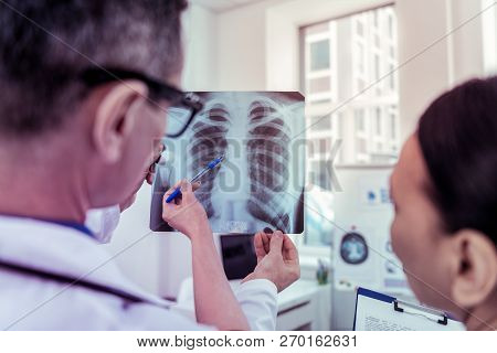 Two Medical Workers Discussing Results On Roentgen