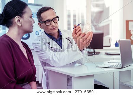 Attentive Asian Woman Listening To Her Doctor