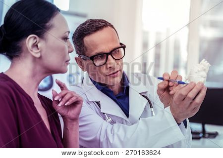 Close Up Of Competent Doctor That Staring At Artificial Organ