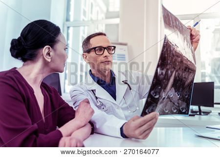 Attentive Medical Worker Looking At Roentgen Photo