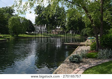 Giant Pond Lake Lagoon In A Residential Neighborhood In Summer Surrounded By Green Lush Trees