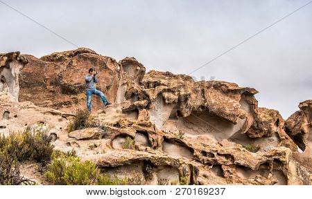 Amazing scenery of mountanious Bolivian landscape and man taking photo at the rocks