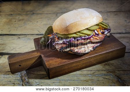 Brisket Sandwich With Cucumber And Coleslow On Cutting Board