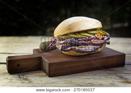 Brisket Sandwich With Cucumber And Coleslow On Cutting Board
