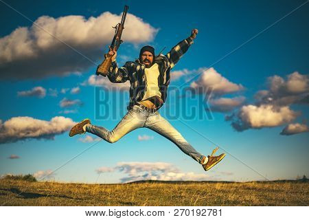 Hunter With Shotgun Gun On Hunt. Crazy Hunter On Sky Background