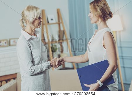 Social Worker Shaking Hands With Her Elderly Client