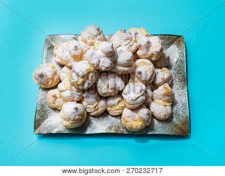 Homemade Profiteroles Served On A Plate, On A Blue Background. Stock Image.