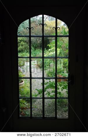 Silhouette der ein gotisches Fenster mit Blick auf einen grünen Garten