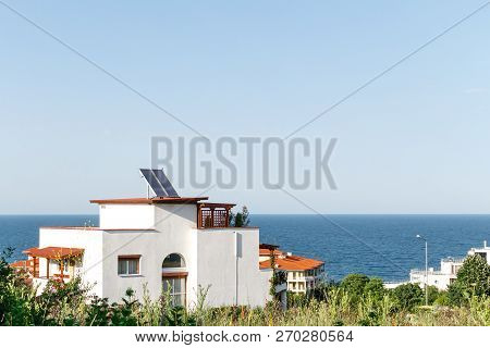 White House With Solar Water Heating Panel On The Roof And Sea Background Against Blue Sky. Byala, B