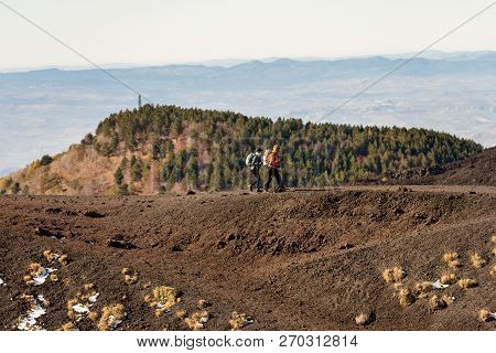 Catania, Mount Etna Volcano, Italy, Dec 8, 2017: A Couple Of Hikers Walk Along An Extinct Crater On 