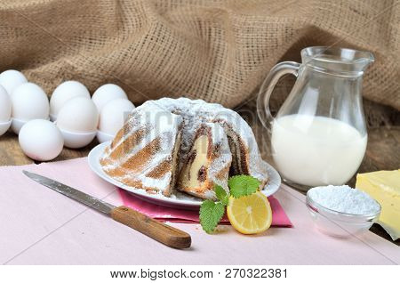 Sliced Homemade Marble Cake Sprinkled With Sugar, Lemon, Melissa, Milk, Eggs And Butter