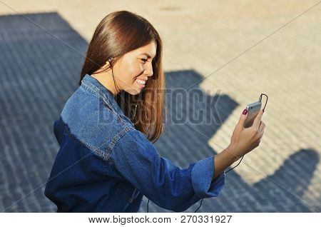 Young Cute Student Talking On The Phone By Video On The Street And Smiling Holding The Phone In Fron