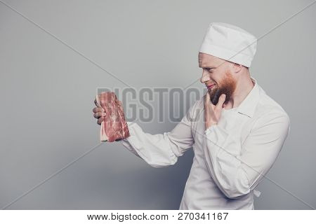 Profile Side View Portrait Of Nice Handsome Minded Butcher Guy Holding Fresh Meat In Arm Hand Thinki