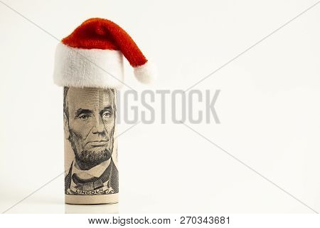President Lincoln Is Like Santa Claus. A Five-dollar Us Bill Is Rolled Into A Tube And A Red Cap At 