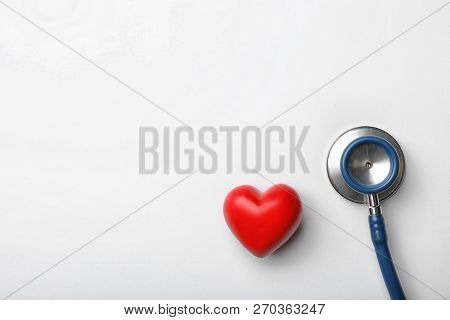 Stethoscope For Checking Pulse And Red Heart On White Background, Top View. Space For Text
