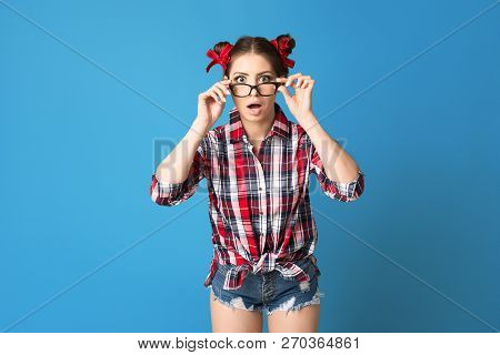 Surprised Hipster Girl Wearing Glasses With Two Buns Hairstile On Blue Background