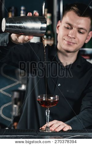 Bartender Making Boulevardier Cocktail Pouring Fluid Into Glass. Bar On A Background