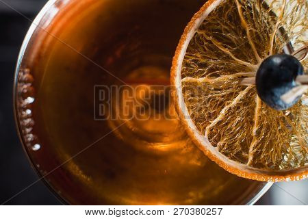 The Boulevardier Cocktail With Orange Chips On Top. On A Bar Desk