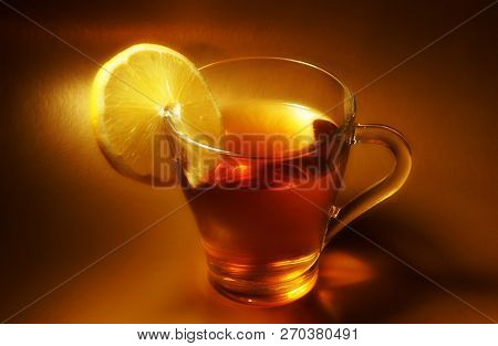 Drinking Tea With Lemon In A Glass Mug Brown Background Close-up