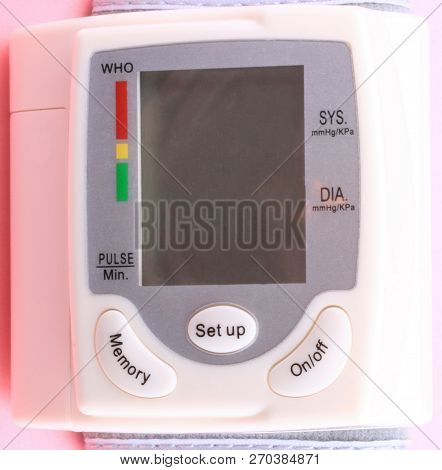 Automatic Wrist Digital Blood Pressure Monitor On Pink Background At Dry Day