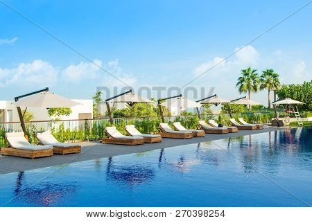 Ajman, United Arab Emirates - 30 October 2018: Pool Area With Sunbeds And Umbrellas In A Luxury Hote
