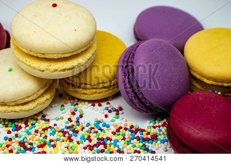 Macaroons Close - Up With Culinary Decor Isolated On A Light Background.
