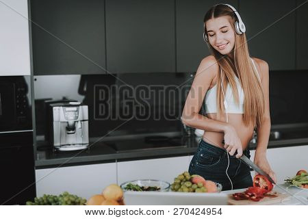 Girl Is Cooking And Listen To Music In Headphones. Healthy Lifestyle. Young And Handsome. Sport Body