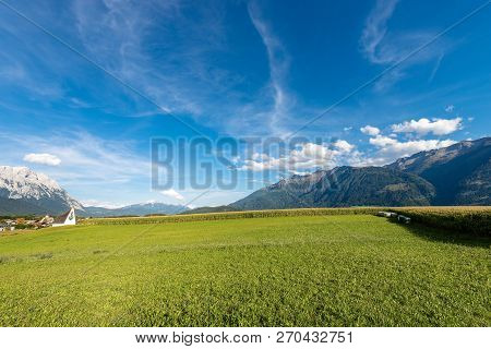 Green Corn Fields And A Meadow In Mountain Near The Small Village Of Obermieming, Austrian Alps, Tyr