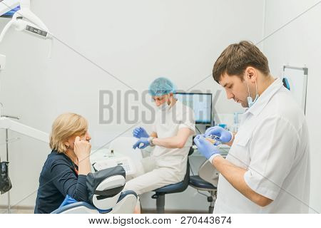 Doctor Used Microscope. Dentist Is Treating Patient In Modern Dental Office. Operation Is Carried Ou