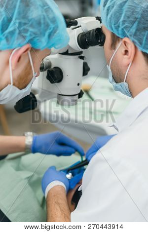 Doctor Used Microscope. Dentist Is Treating Patient In Modern Dental Office. Operation Is Carried Ou