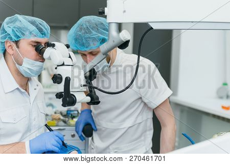 Doctor Used Microscope. Dentist Is Treating Patient In Modern Dental Office. Operation Is Carried Ou