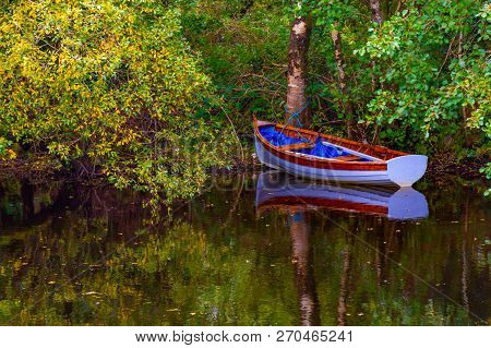 Boat And Trees With Reflection In Owenriff River
