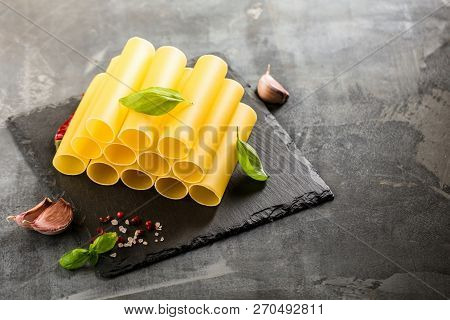 Fresh Raw Homemade Connelloni Pasta On Dark Table.