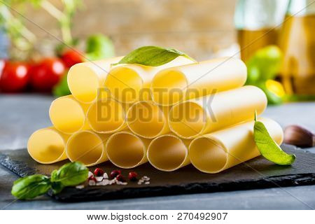 Fresh Raw Homemade Connelloni Pasta On Dark Table.