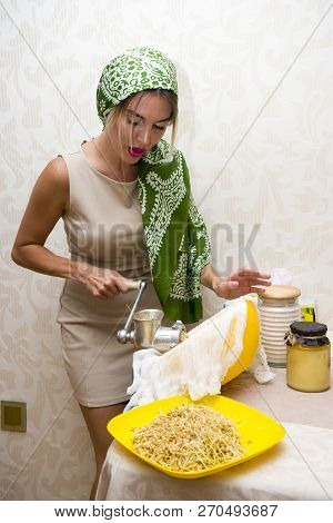 Young Beautiful Woman In An Apron Making Cake With Cream And Berries At The Kitchen