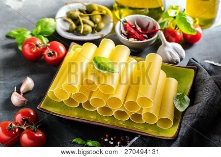 Fresh Raw Homemade Connelloni Pasta On Dark Table.