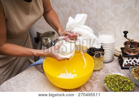 Young Beautiful Woman In An Apron Making Cake With Cream And Berries At The Kitchen