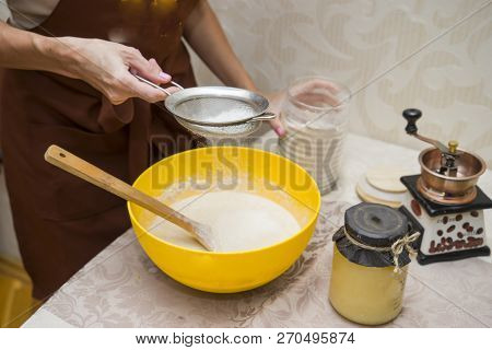 Young Beautiful Woman In An Apron Making Cake With Cream And Berries At The Kitchen