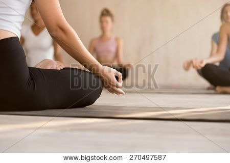 Young Woman Practicing Yoga, Instructor And Group Doing Sukhasan
