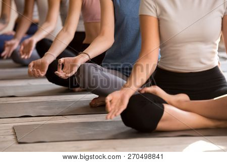 Group Of Women Practicing Yoga In Easy Seat, Close Up