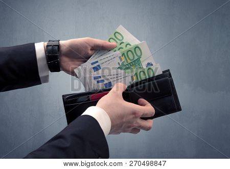 Businessman's hand in suit takes out eruo from his wallet